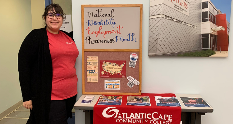 Juliana Torres, Specialist, Center For Accessibility, stands next to an information table